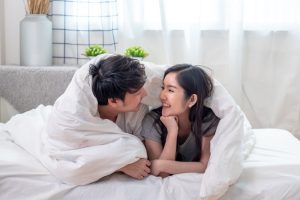 Lovely,Young,Asian,Couple,Covered,With,White,Blanket,On,White
